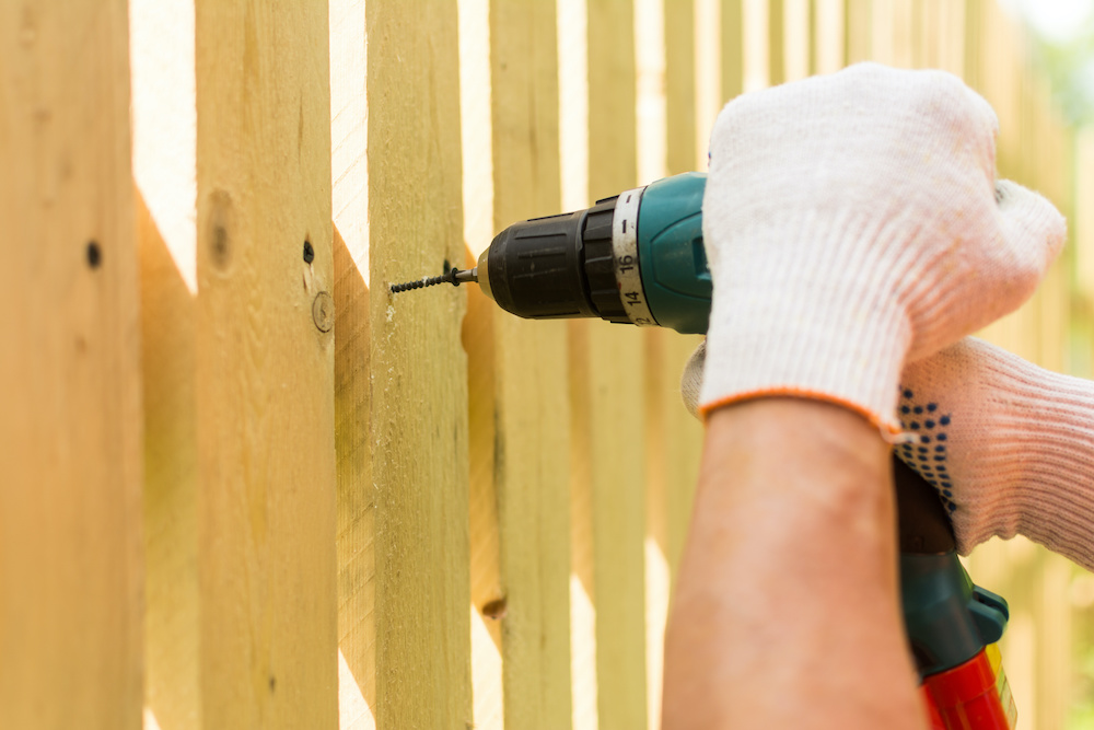 Hands of the carpenter holding electric screwdriver in work close up carpenter holding electric screwdriver